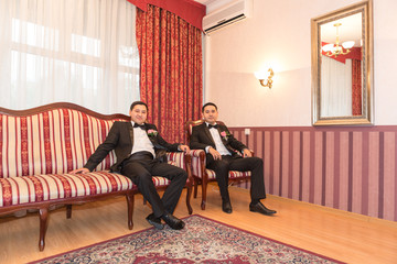 Groom and  groomsman in room