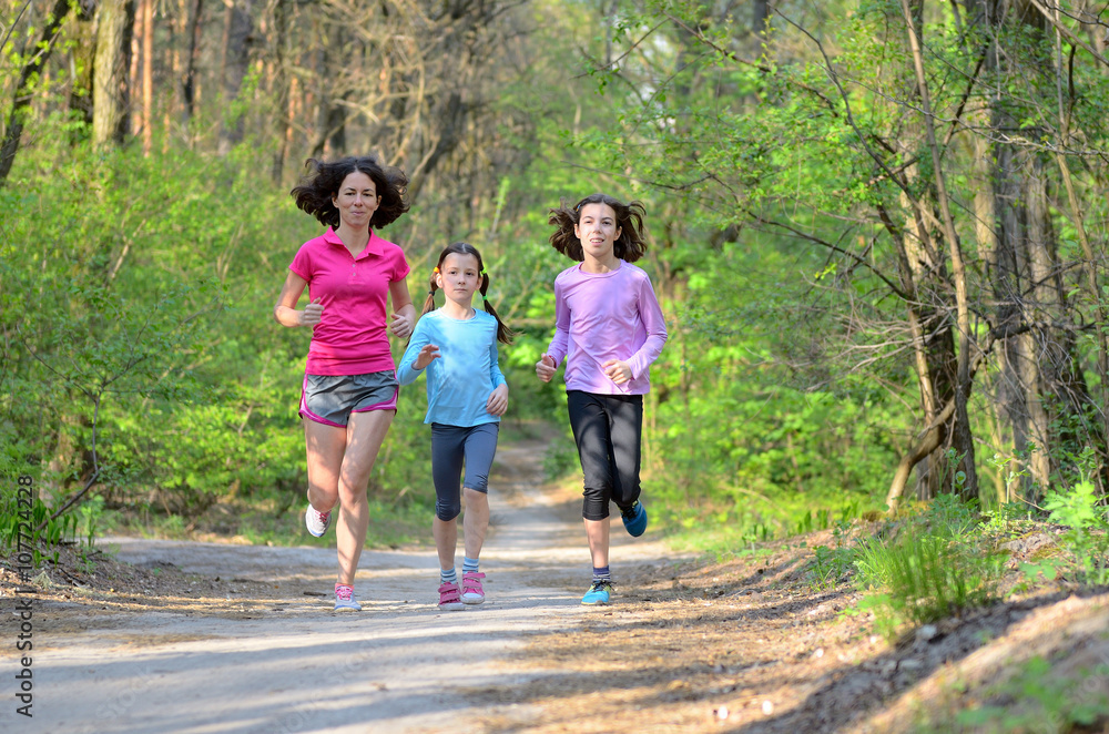 Wall mural Family sport, happy active mother and kids jogging outdoors, running in forest
