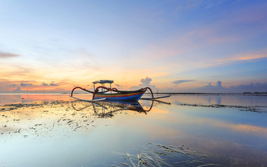 Traditional Balinese ships Jukung at sunrise, in Sanur, Bali, Indonesia