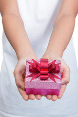 Two female hands holding box of present
