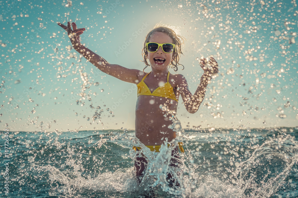 Sticker Happy child playing in the sea