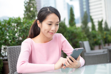 Woman use of mobile phone at outdoor cafe