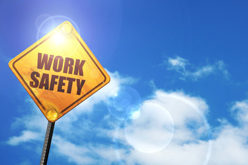Yellow road sign with a blue sky and white clouds: work safety