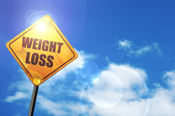 Yellow road sign with a blue sky and white clouds: weight loss