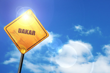 Yellow road sign with a blue sky and white clouds: dakar