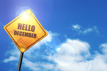 Yellow road sign with a blue sky and white clouds: hello decembe