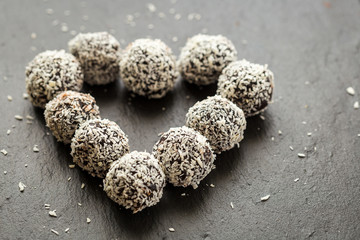 Homemade Healthy Paleo Raw Chocolate Truffles with Nuts, Dates and Coconut Flakes Arranged in Heart Shape