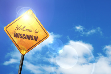 Yellow road sign with a blue sky and white clouds: Welcome to wi