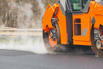 Road roller flattening new asphalt
