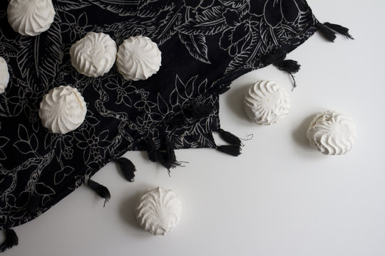 Top view of Latvian marshmallovs - zefiri on white background with dark floral tablecloth