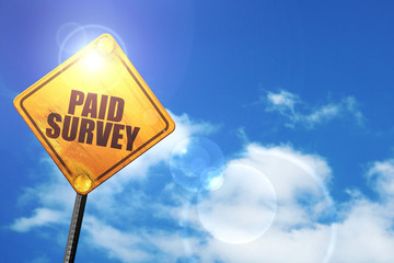 Yellow road sign with a blue sky and white clouds: paid survey