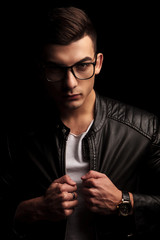closeup portrait of man wearing glasses, pulling black leather j