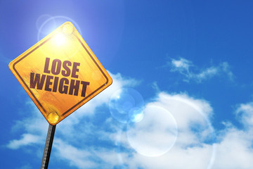 Yellow road sign with a blue sky and white clouds: lose weight