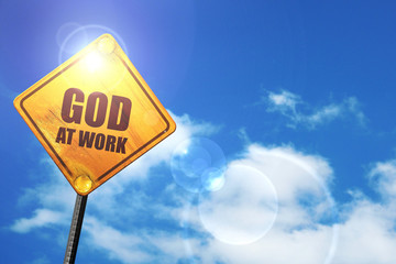 Yellow road sign with a blue sky and white clouds: god at work