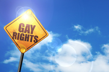 Yellow road sign with a blue sky and white clouds: gay rights