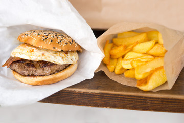 Tasty hamburger with french fries in  a paper