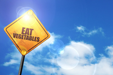 Yellow road sign with a blue sky and white clouds: eat vegetable