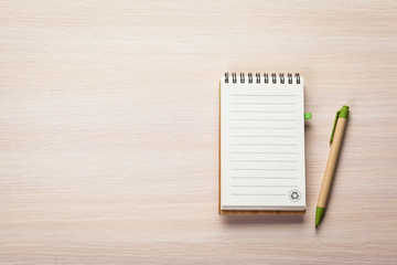 Blank note paper with pen on wood background