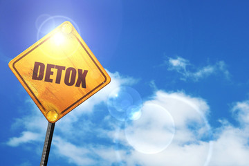 Yellow road sign with a blue sky and white clouds: detox
