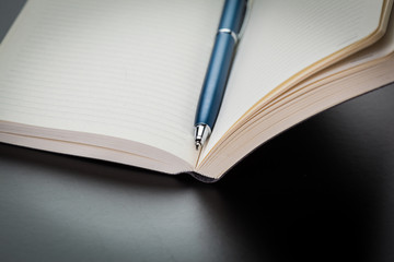 blank notebook and pen on the table