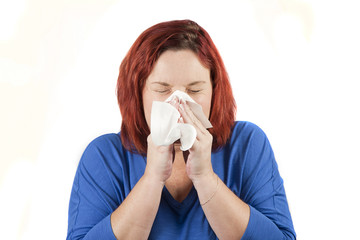 Caucasian woman blowing nose