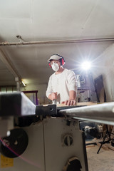 Fototapeta premium Carpenter working on wood machine in factory