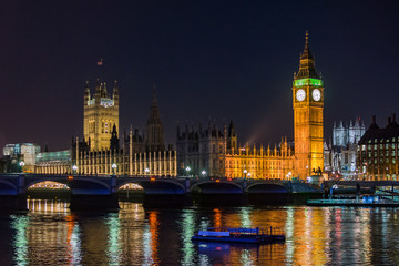 Fototapeta na wymiar London Big Ben Westminster parliament Thames with boat and bridge in night