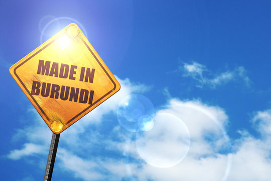 Yellow road sign with a blue sky and white clouds: Made in burun