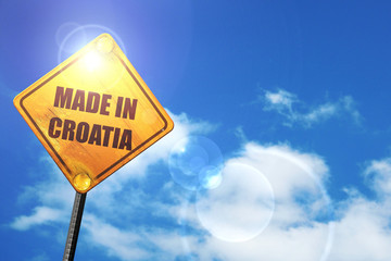 Yellow road sign with a blue sky and white clouds: Made in croat