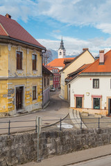 Obraz premium Small European medieval street overlooking the church and mountains on the background.