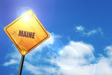 Yellow road sign with a blue sky and white clouds:  maine