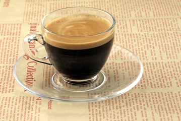 Single Transparent Coffee Cup With Espresso On The Newspaper
