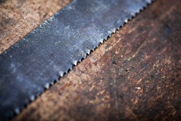 Hacksaw on wooden plank
