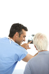 Fototapeta premium Doctor showing dental X-ray to senior patient