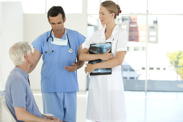Doctor and nurse talking to senior patient at the hospital