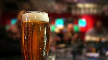 Pint glass of lager on pub table 
