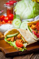 Fried chicken meat with vegetables in pita bread