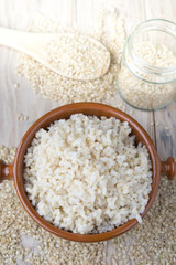 Cooked steamed rice in a blue bowl over wooden background