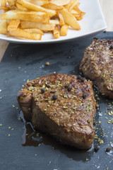 cooked beef chateaubriand steak with chunk chipped potatoes on p