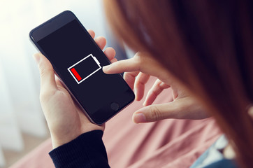 Woman hands using smart phone with low battery.