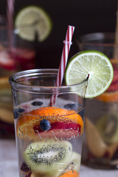 Detox water with fruit in glasses served in wooden tray. Rustic