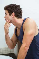 Man checking his stubble in bathroom