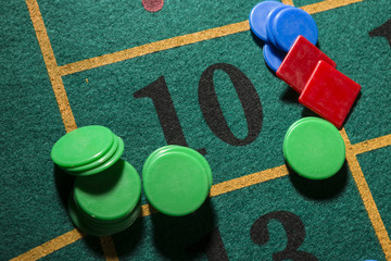 Dettaglio di fiches su tavolo verde da gioco al numero 10