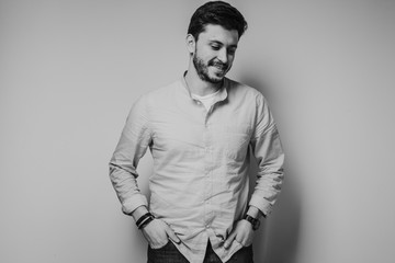 black and white portrait of handsome smiling man isolated on gray studio background posing to the camera