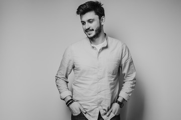 black and white portrait of handsome smiling man isolated on gray studio background posing to the camera