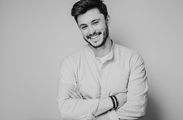 black and white portrait of handsome smiling man isolated on gray studio background posing to the camera