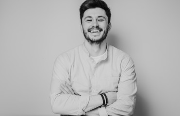 black and white portrait of handsome smiling man isolated on gray studio background posing to the camera