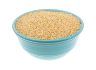 Bowl filled with turbinado sugar on a white background