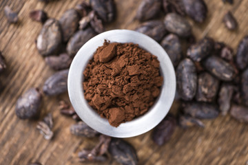 Cocoa powder on wooden background