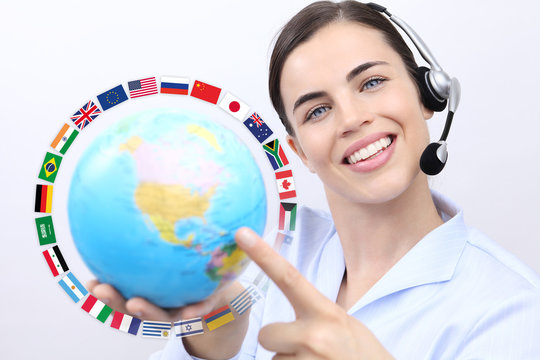 Customer service operator woman with headset smiling, holding globe